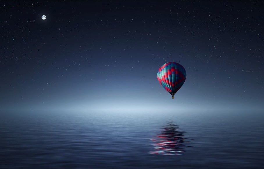 Air-balloon at night, over the water.